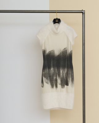 un t-shirt noir et blanc suspendu à un cintre devant un mur jaune