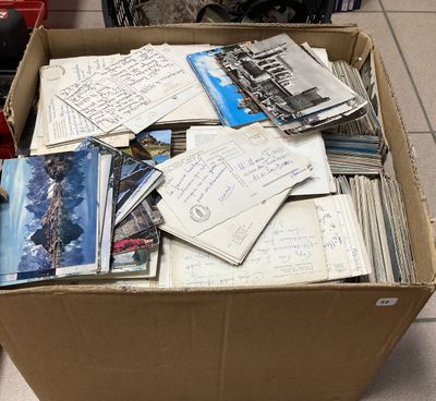 une boîte en carton remplie de vieilles cartes postales et d'autres objets