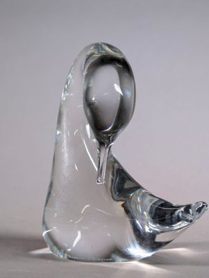 a glass sculpture of a bird that is sitting on a table