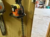 une photo représentant une tronçonneuse et une autre tronçonneuse accrochée au mur