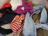 a pile of clothes sitting on top of a bed