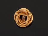 an image of a gold and diamond broochle on a black surface