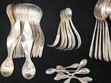 a lot of silver spoons and spoon spoons on a black table