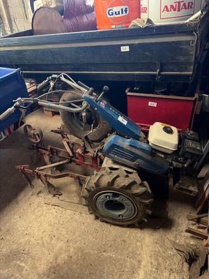 a blue tractor that is parked in a garage