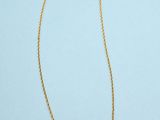 a gold necklace with a chain on a blue background