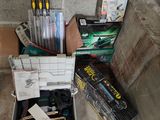 une boîte remplie de stylos et d'autres fournitures de bureau posée par terre
