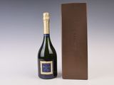 the bottle of champagne is next to a box of chocolate