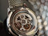 a close up of a watch with a chain around it