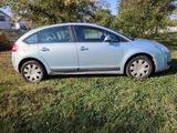 a picture of a small blue car parked in the grass