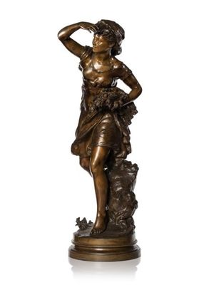 a bronze statue of a woman standing on a rock with her hands on her head