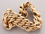 an image of a close up of a gold bracelet on a white surface