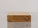 an image of a gold lighter sitting on top of a table