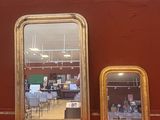 trois miroirs posés sur une table rouge dans une pièce