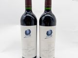 deux bouteilles de vin rouge posées l'une à côté de l'autre sur une surface blanche