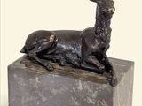 statue d'un cerf assis sur un bloc de marbre