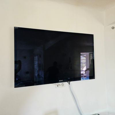une télévision à écran plat fixée au mur dans le salon