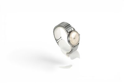 a close up of a watch on a white surface with a white background