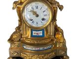 une horloge en or surmontée d'un oiseau