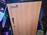 une petite armoire sur laquelle est posé un aspirateur, dans une pièce encombrée