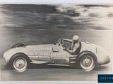 une photo en noir et blanc d'un homme au volant d'une voiture de course