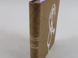 un livre marron avec une étiquette violette dessus