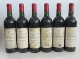 six bottles of wine are lined up in a row on a table