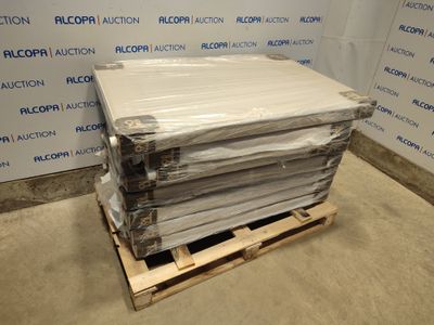 une pile de draps blancs posée sur une palette devant un mur