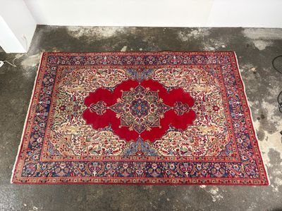 an oriental rug on the floor in a corner of a room