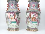 une paire de vases chinois posés sur une surface blanche