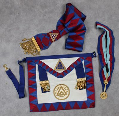un tablier bleu et rouge orné d'une médaille d'or et d'un nœud papillon