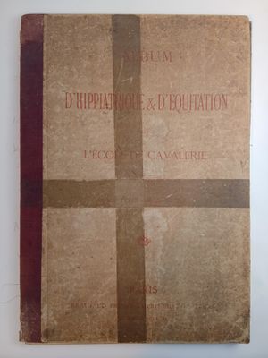 un vieux livre posé sur une table à côté d'un mur blanc