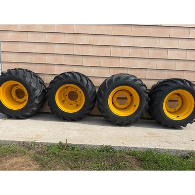 four large tires are lined up against a wall in front of a house