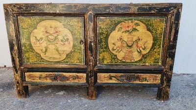 deux armoires en bois ornées de motifs peints, posées à même le sol