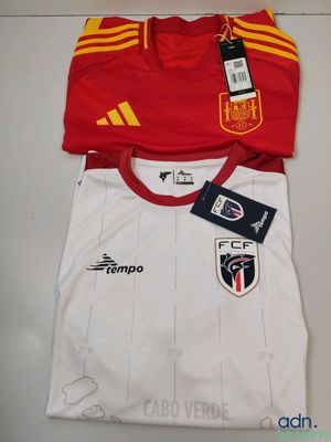 Le t-shirt est rouge et blanc, avec une bande jaune dessus.