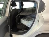 a white car with the door open and a bed in the back