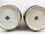 pair of white and brown vases sitting on top of a white surface