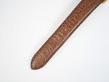 brown leather watch strap on a white surface with a gold clasp