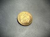 a close up of a gold coin on a gray surface