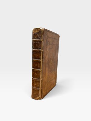 an old book with a brown cover sitting on top of a white surface