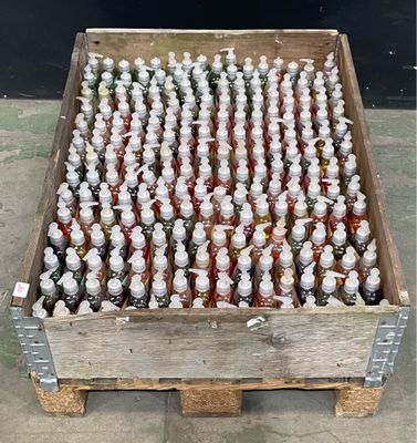 plusieurs bouteilles de sirop dans une caisse en bois