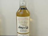 une bouteille de whisky posée sur un comptoir, à côté d'une bouteille de vin