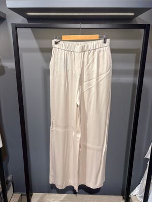 Le pantalon blanc est suspendu à une patère dans le placard.