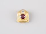 a close up of a gold ring with a red stone