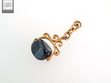 un gros plan d'un collier plaqué or orné d'une pierre bleue