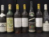 many bottles of wine that are lined up on a table
