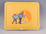 a yellow tray with a picture of two people and a dog on it
