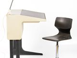 a desk with a chair and a lamp on it