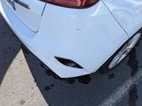 a close up of a white car parked in a parking lot