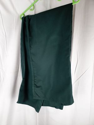 une jupe verte suspendue à un cintre vert sur un drap blanc