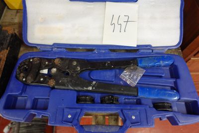 une caisse à outils bleue avec des outils sur le sol